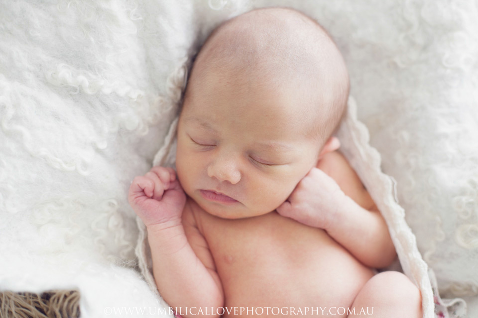 Wagga-Wagga-Newborn-Baby-Photographer baby sleeping on a white throw with her hand under her chin