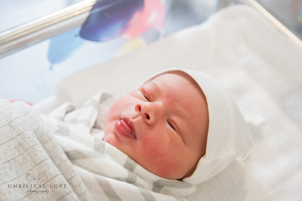 one day old baby poking tongue out