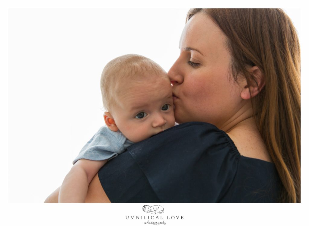 mum giving baby son a kiss on his head