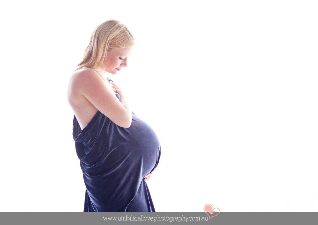 pregnant mum holding her belly looking down at her big belly