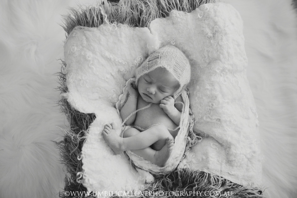 Wagga-Wagga-Newborn-Baby-Photography black and white photo of baby sleeping with a white knitted cap on her head