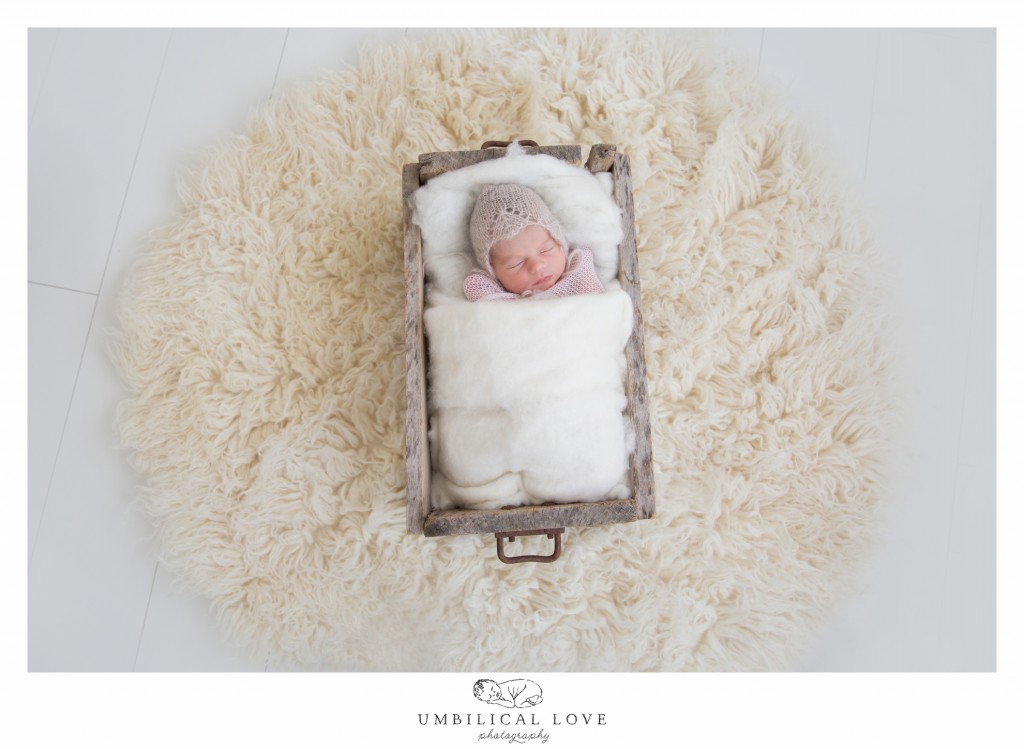 Newborn baby lying in a wooden box