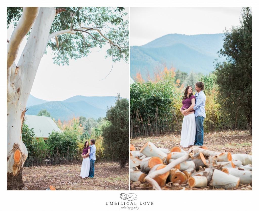Pregnant lady & her husband standing holding each other surrounded by mountains in the background looking at each other