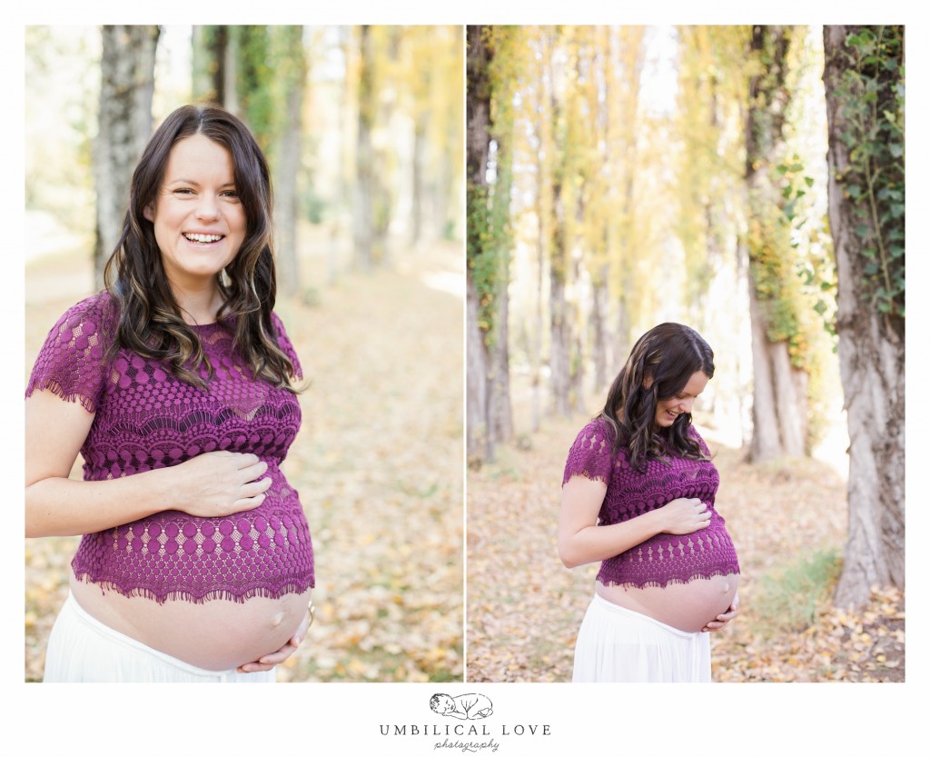 Mum to be looks excited as she holds her pregnant belly looking at the camera