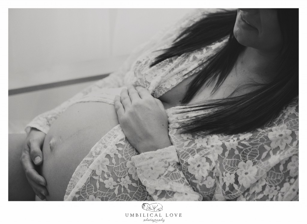 Mum to be sitting on chair holding pregnant tummy