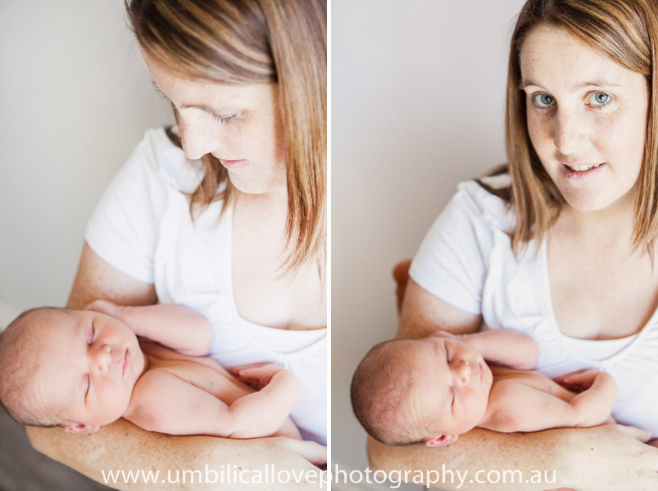 mother holding her sleeping baby and looking at the camera