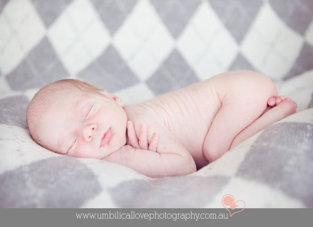 baby curled up in the nude legs under bum asleep