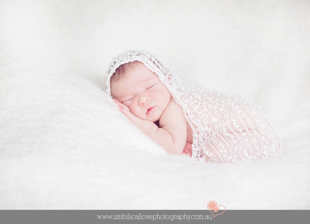 new baby lying on her side swaddled artistically 