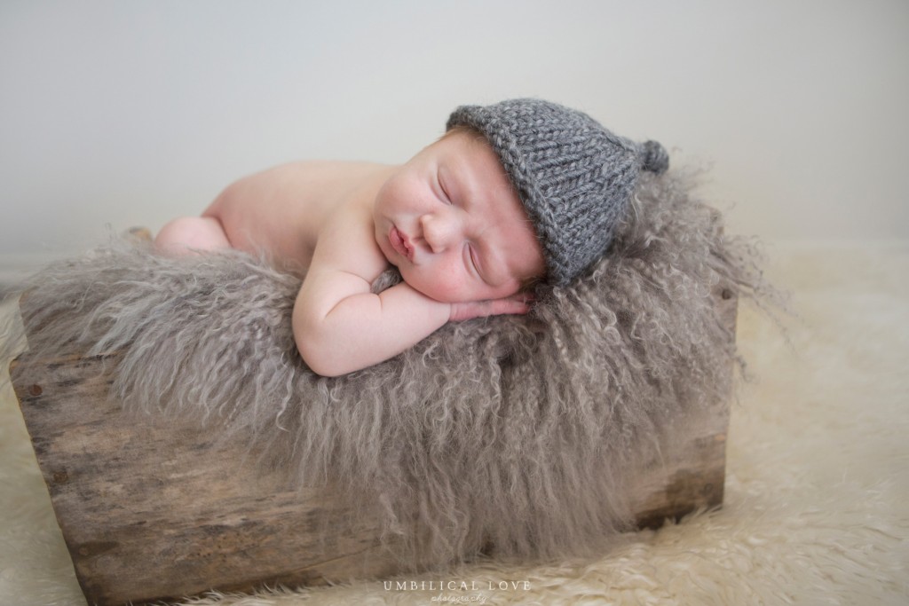 close up of sleeping newborn wearing grey knitted bonnet