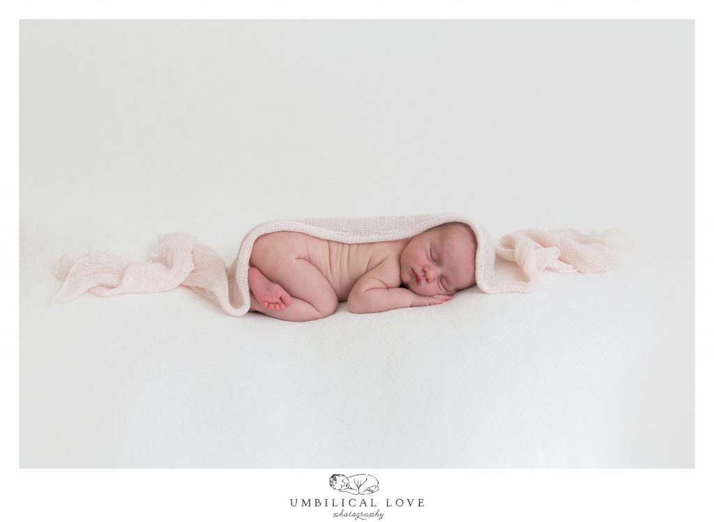 newborn baby girl sleeping with blanket over body