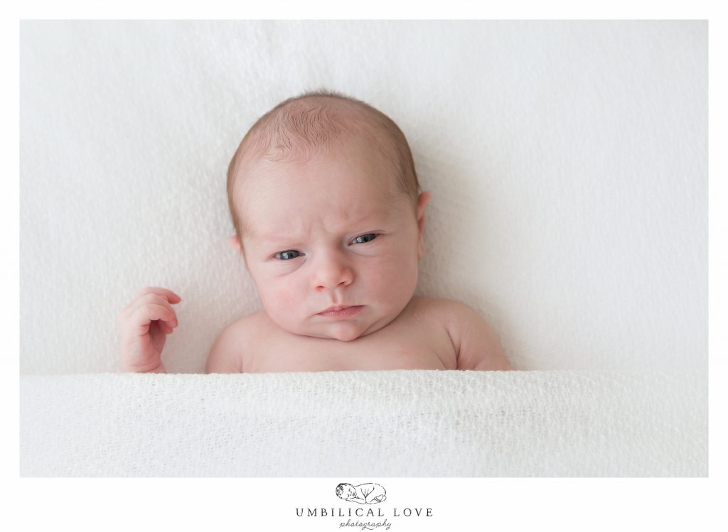 Newborn baby frowning at camera 