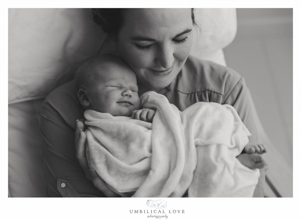 new baby smiling when mum is cuddling her tight 