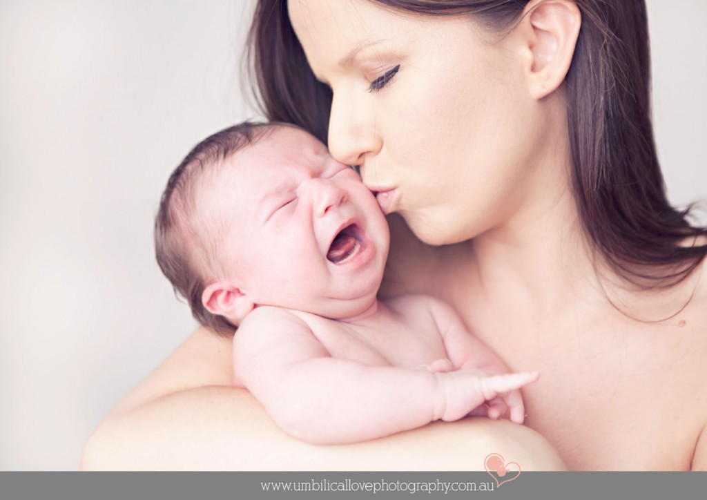 mum kissing her screaming newborn