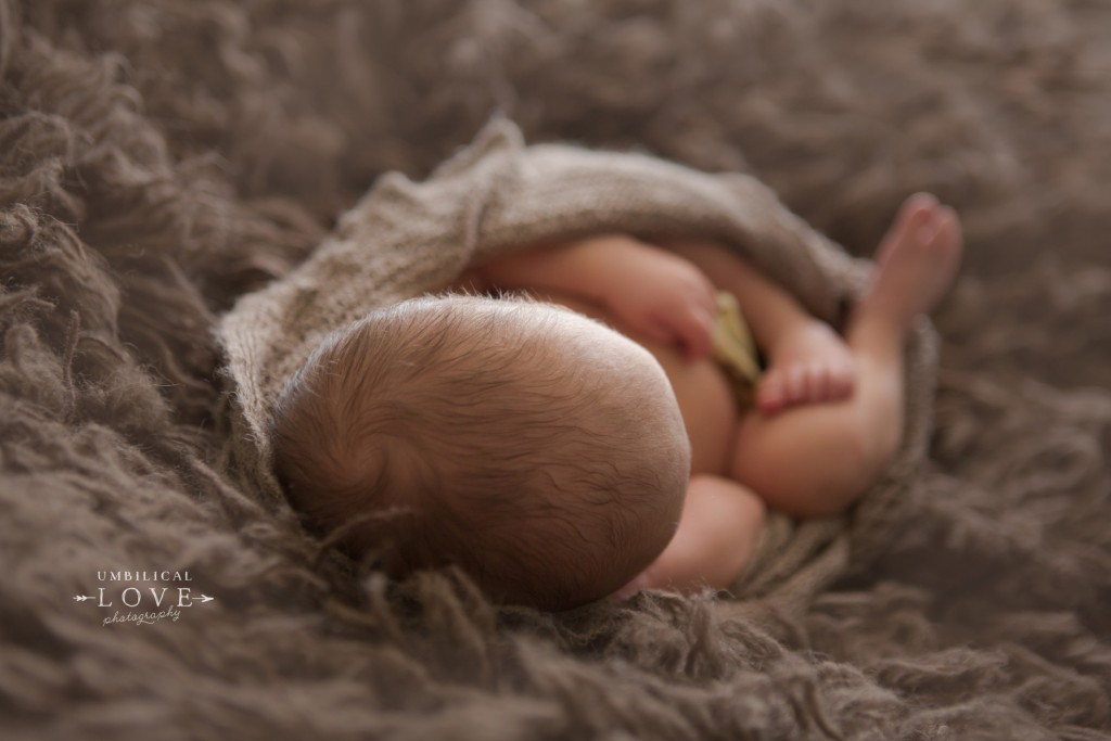 baby sleeping on soft brown ryg