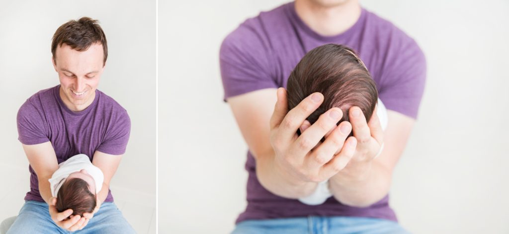 Dad smiles at his baby daughter in his arms