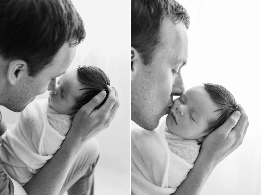 New dad kisses his daughter on the cheek and rubs noses with her