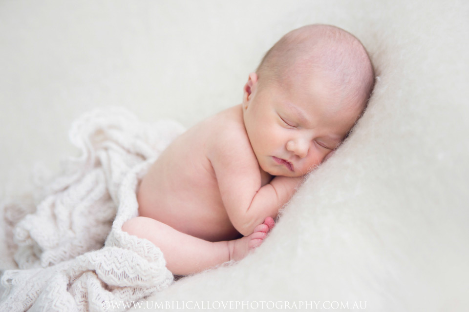Wagga-Wagga-Newborn-Baby-Photographer baby sleeping with her feet up near her elbows