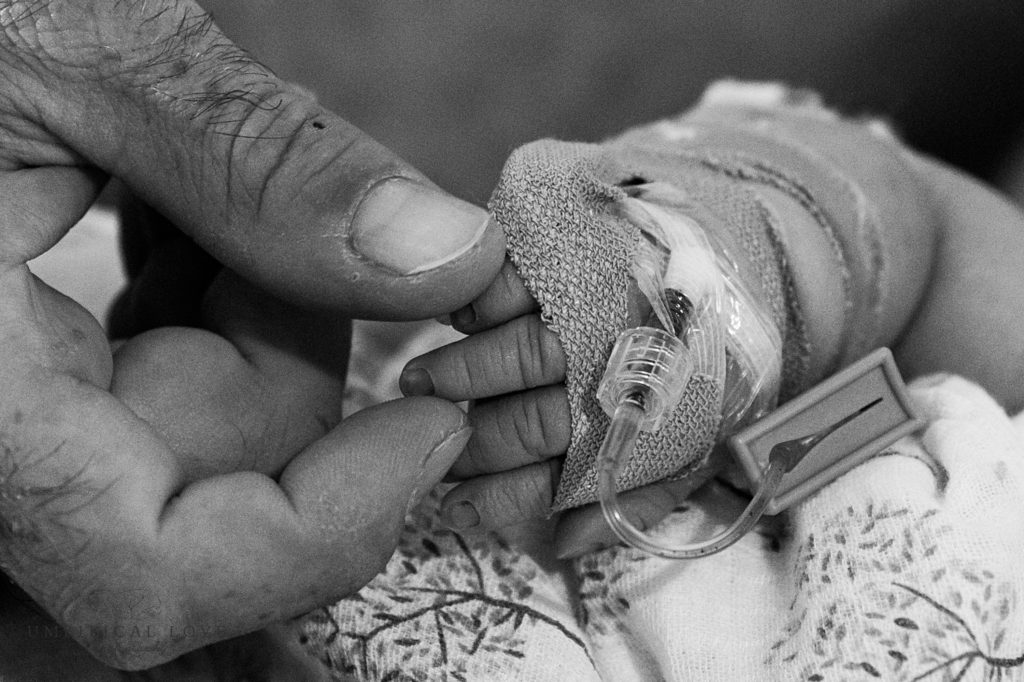Dad holds baby daughters tiny fingers