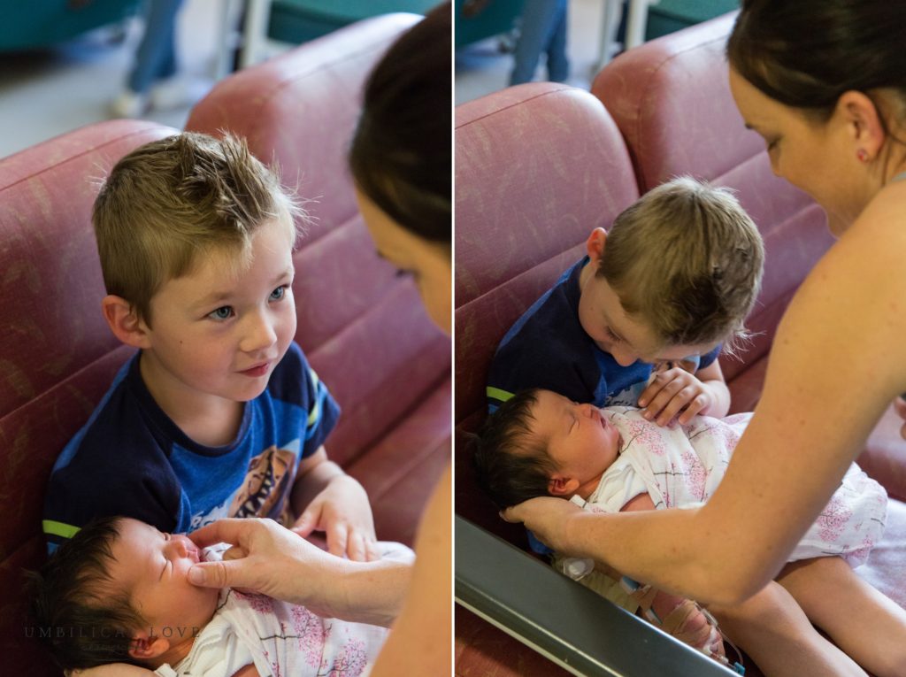 Son looks up at mum as he holds his new baby sister