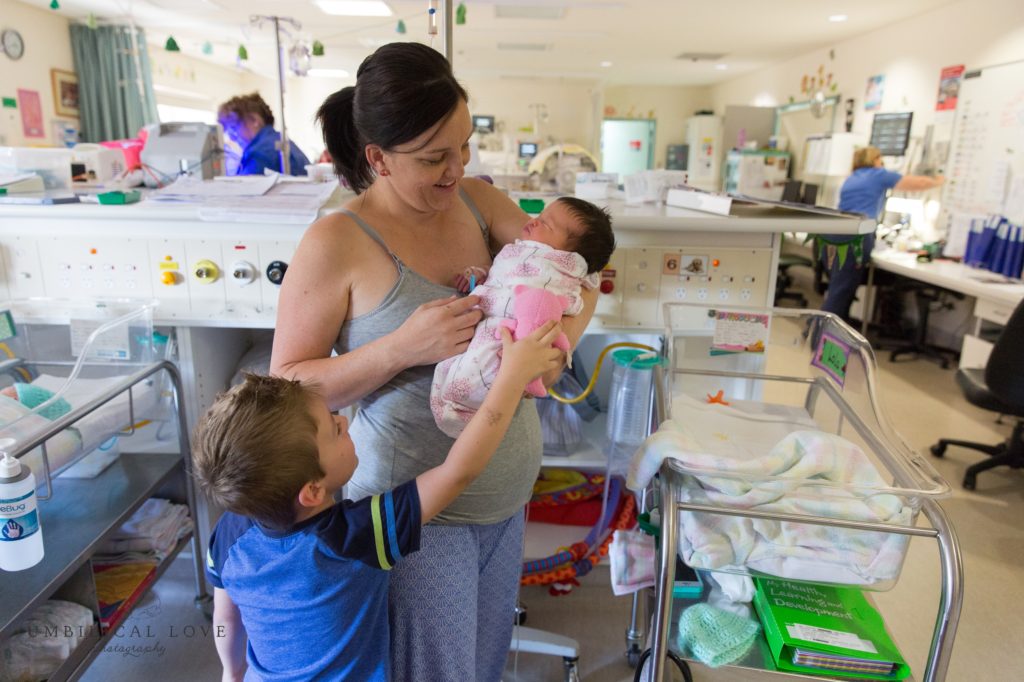 Mum holds new baby daughter in the special care unit of the hospital