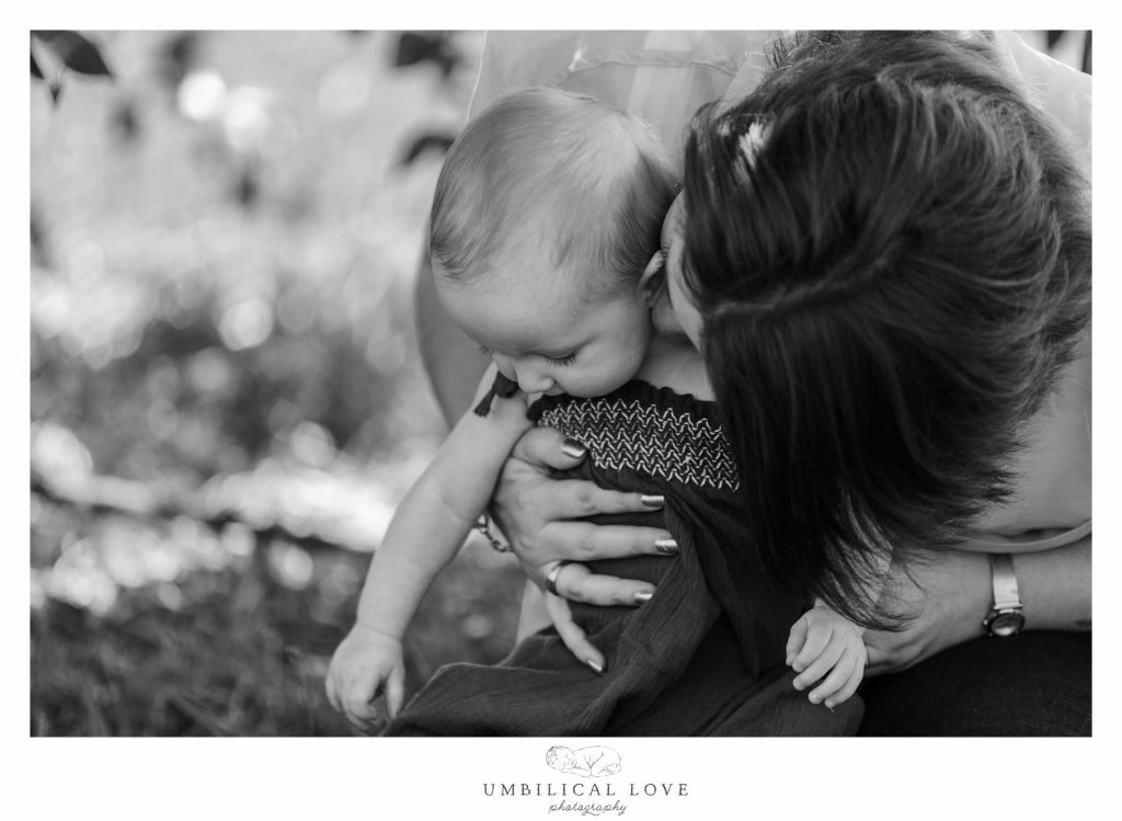 momma giving her baby girl a kiss on the cheek