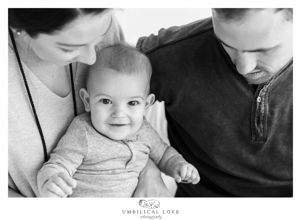 baby looking at camera while mum and dad look at him