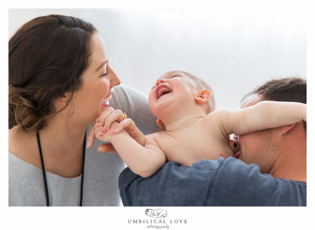 dad giving son raspberry as he throws back his head in laughter