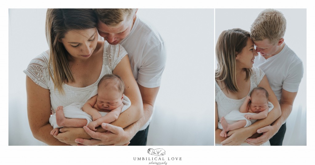 New dad looking over shoulder of mum down at newborn son