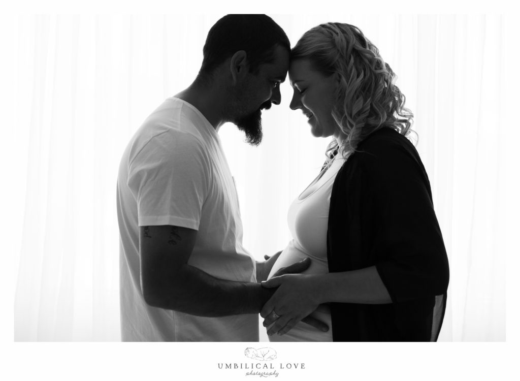 Dad and mum to be hold pregnant tummy
