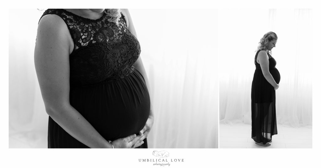 lady in black dress holding her pregnant belly