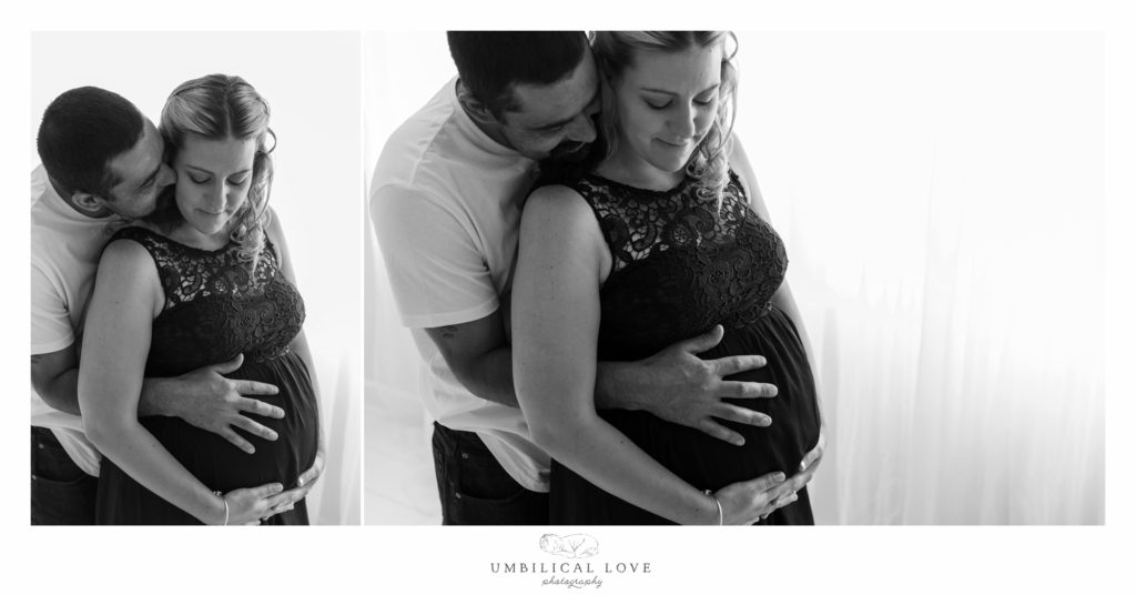 couple stands together holding baby in tummy