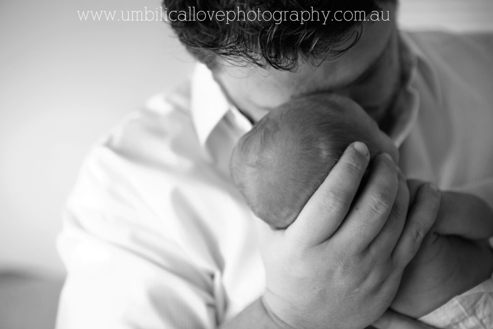 precious moment of dad holding his brand new son close