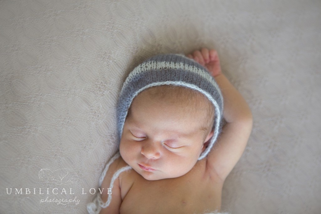 baby girl wearing a knitted grey bonnet