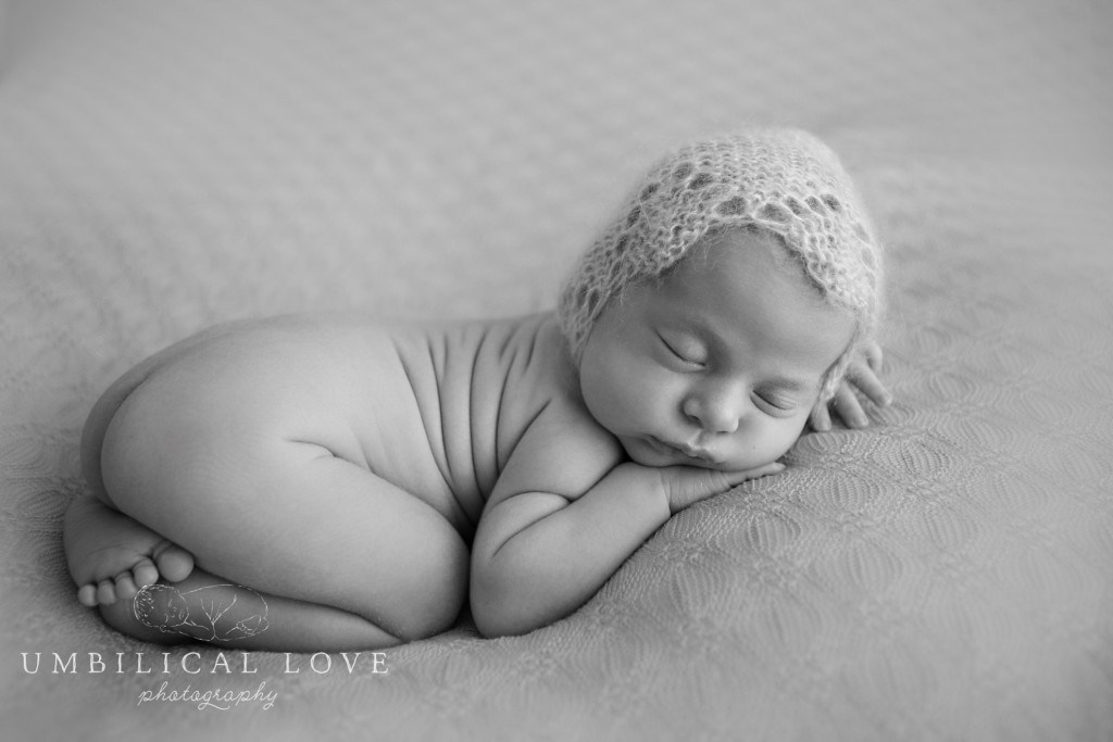 black and white portrait of newborn in fetal position fast asleep