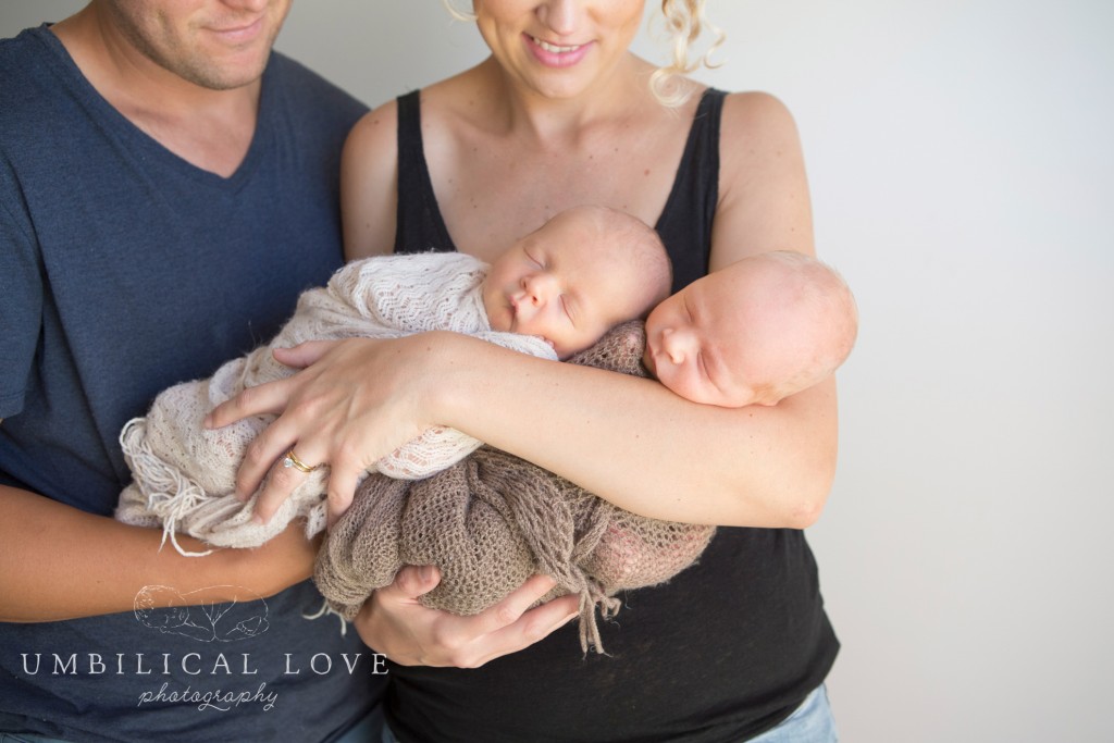 close up of mum and dad holding twin boys