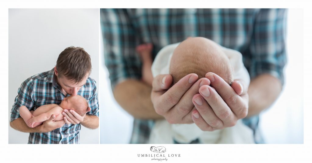 dad holding newborn daughter in his arms with fingers around her head