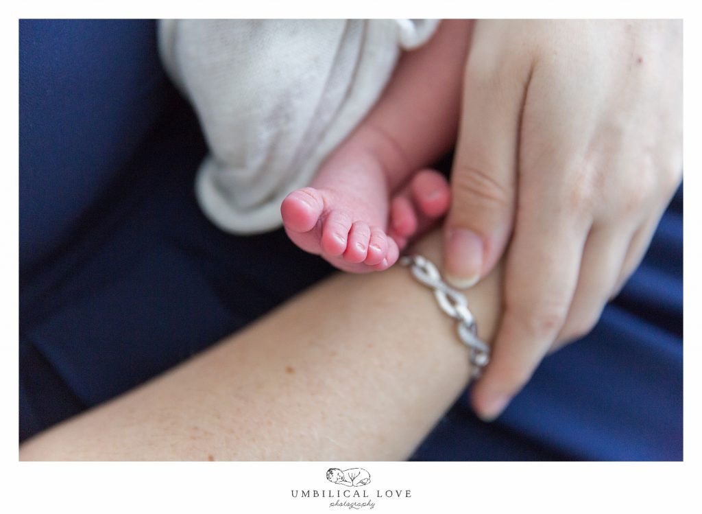newborn foot sticking out as mum holds baby