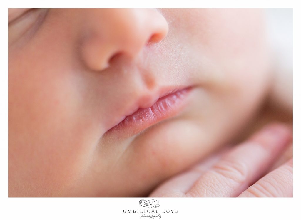 Macro of lips with baby fingers under chin