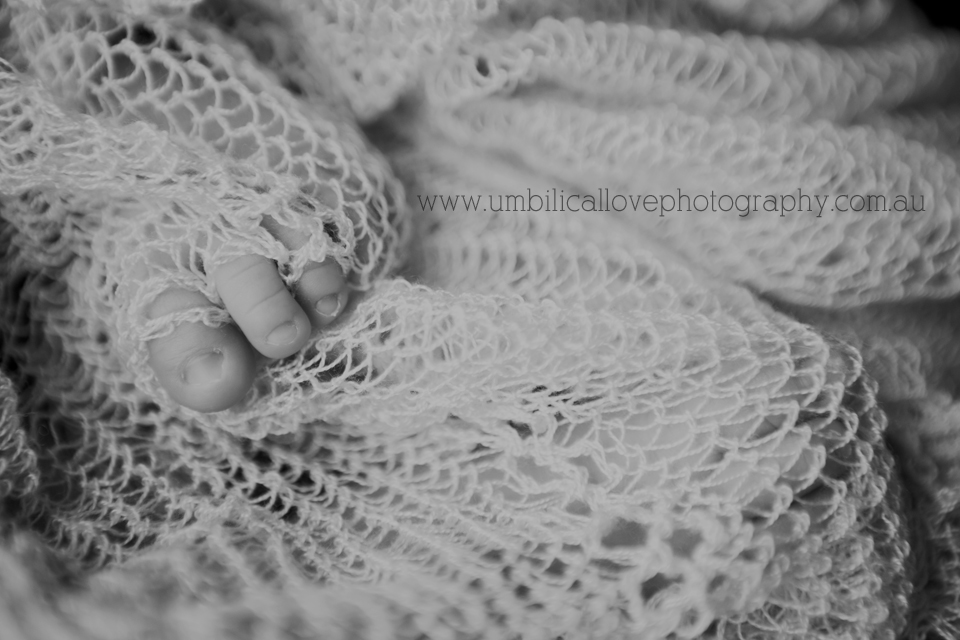 baby boy toes poking out of knitted blanket