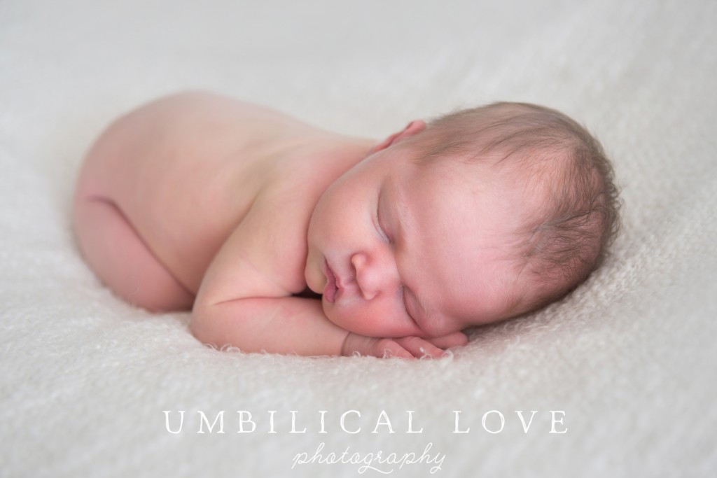 close up of baby sleeping in fetal position