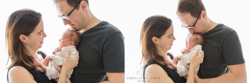 Mum and dad cuddle and kiss their baby daughter