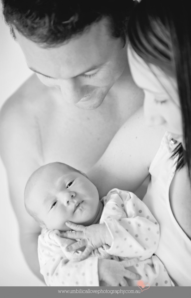 baby photographer North Lakes mum holding her baby and dad looking at his baby girl awake