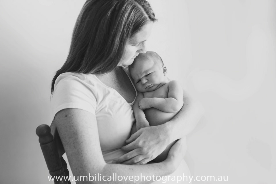 mother looking at the sleeping baby in her arms