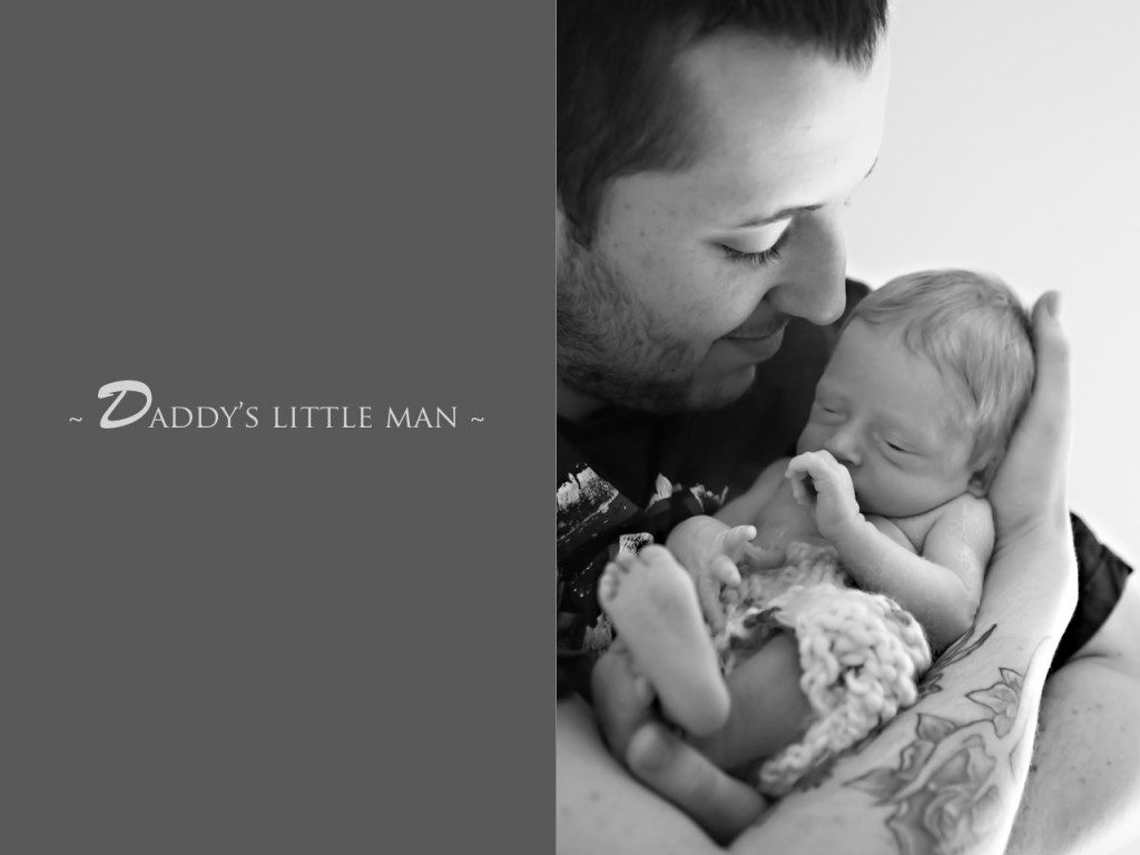 new dad holding his baby close smiling at his newborn son