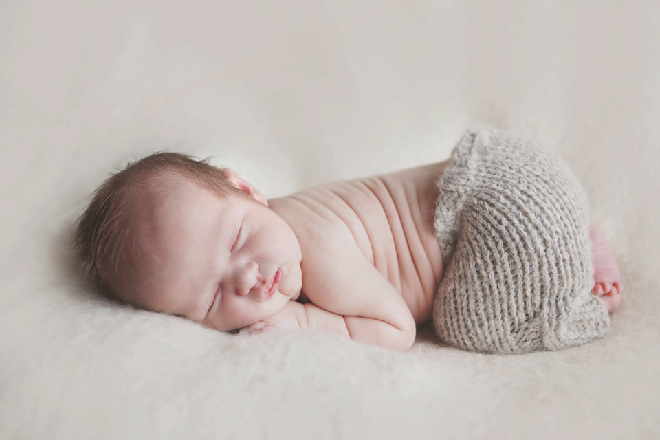 baby asleep on a bean bag with cute knitted pants on