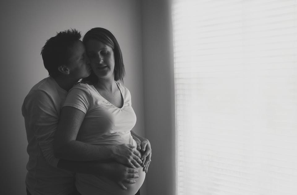 Pregnant lady leaning buck into her hubby giving her a kiss