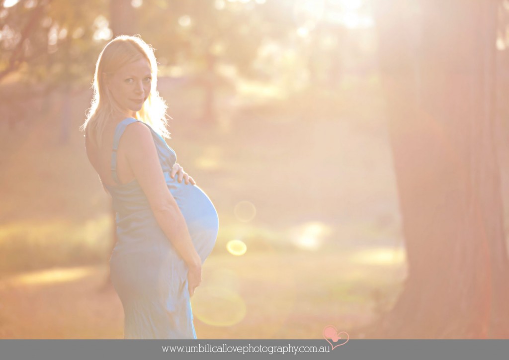 pregnant lady holding her belly in the sun