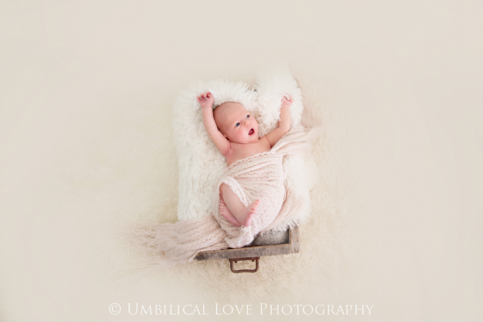baby stretching in her newborn session all wrapped