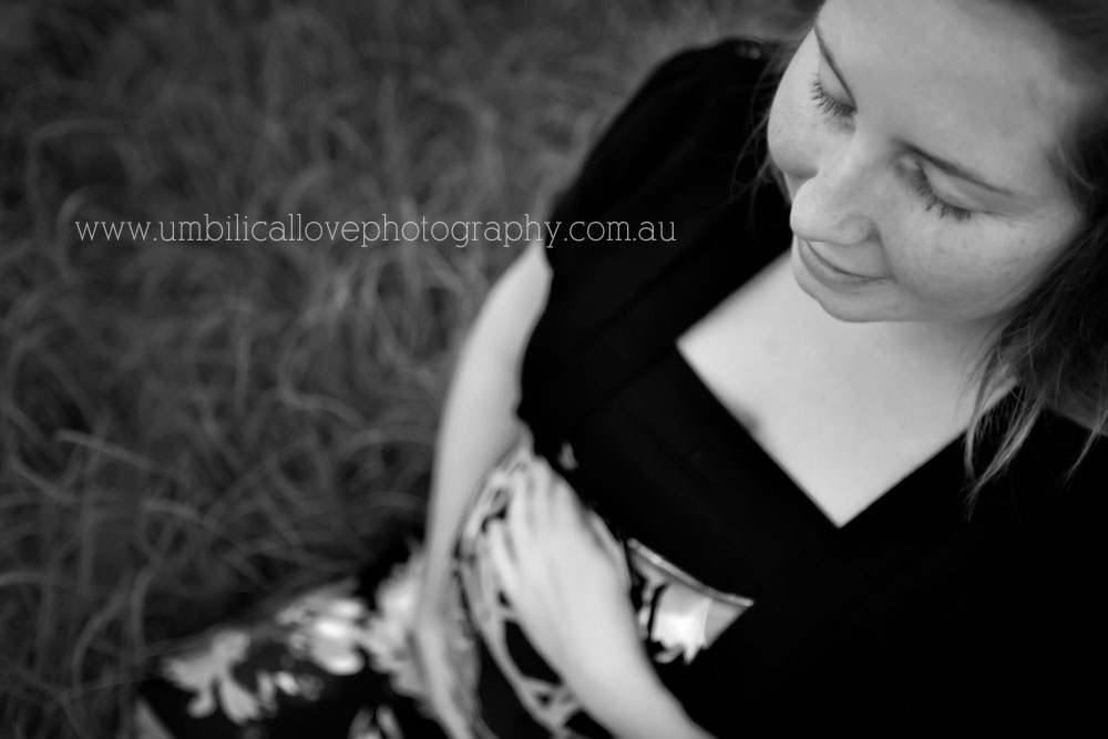 Pregnant lady on the ground holding her belly with her eyes closed