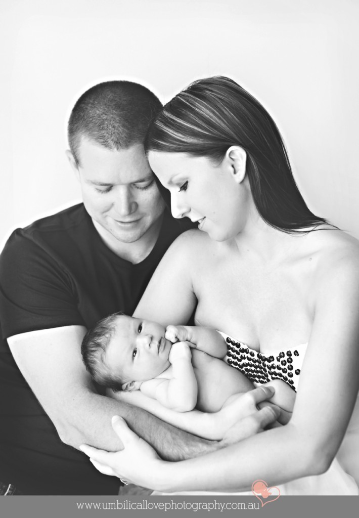 mum cradling her new baby with dad hugging baby and mum
